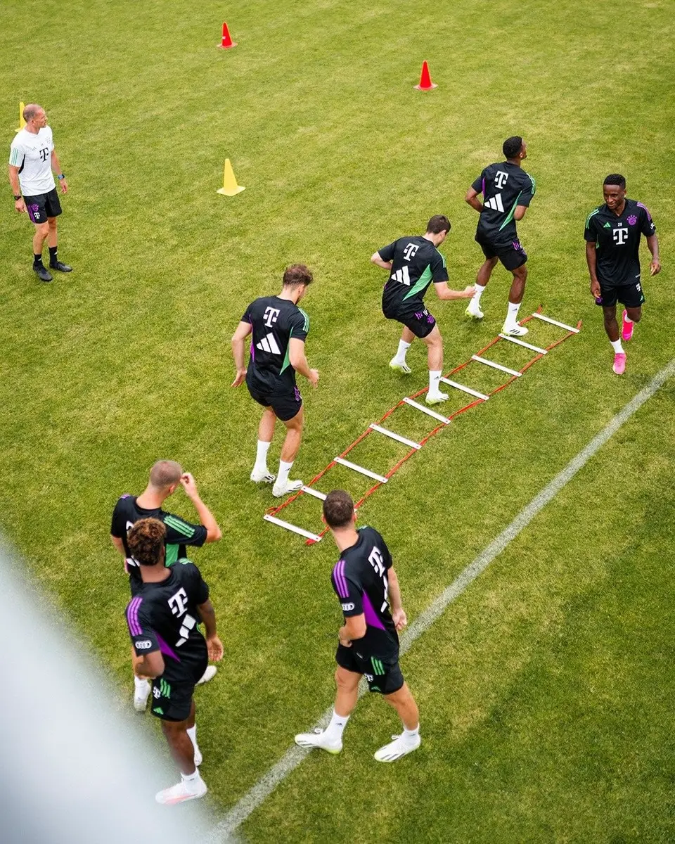 Footballers running a ladder drill on a training pitch, seen from above