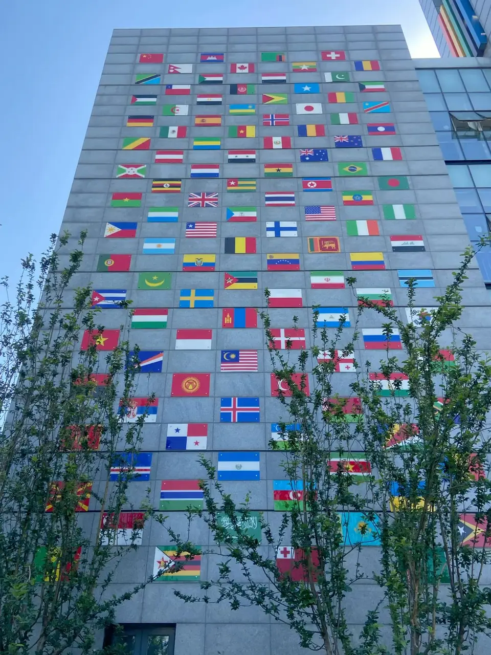 A tall building hung with the flags of many nations