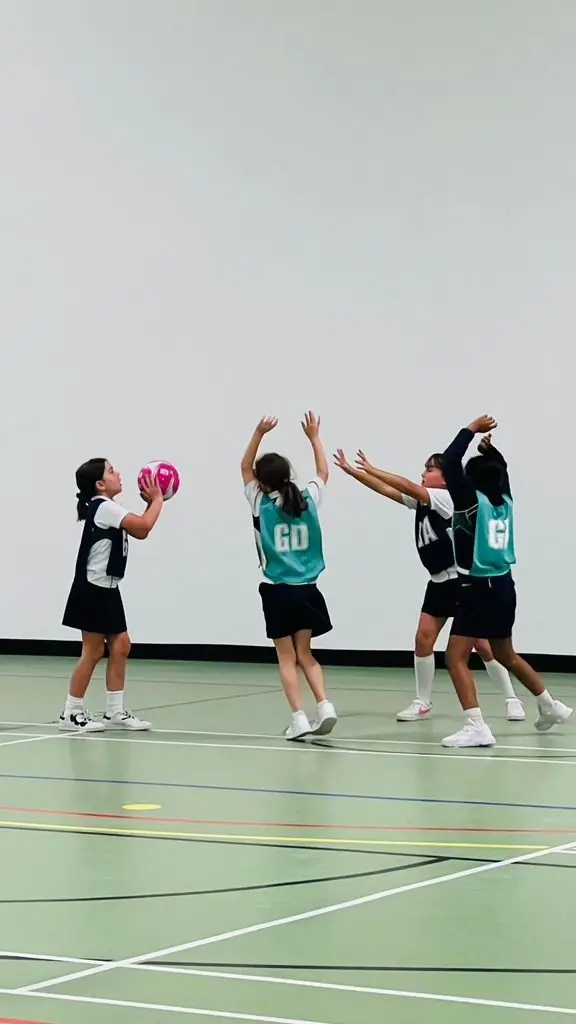 Girls playing netball on an indoor court