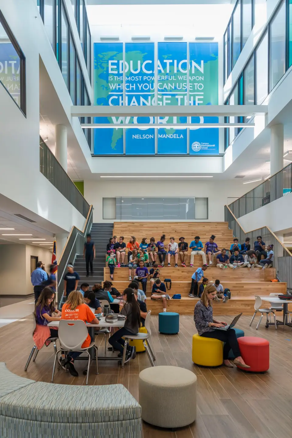 A school atrium full of pupils under a banner about education changing the world