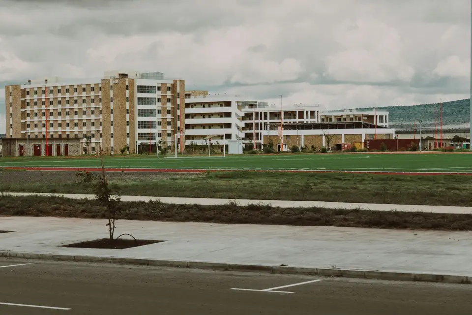 A modern school building beside a green playing field